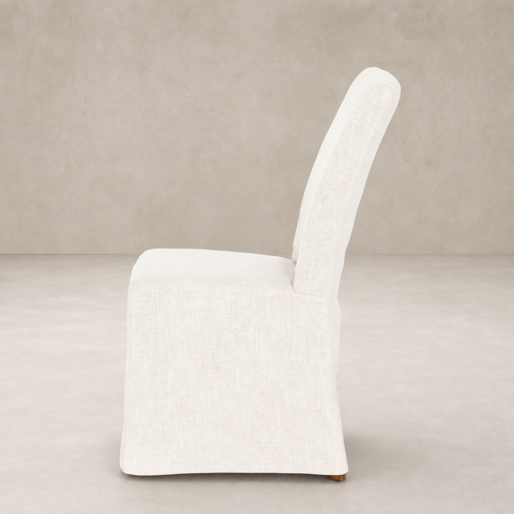 Sierra Slipcovered Dining Chair in a textured beige fabric showcasing its sleek, modern design.