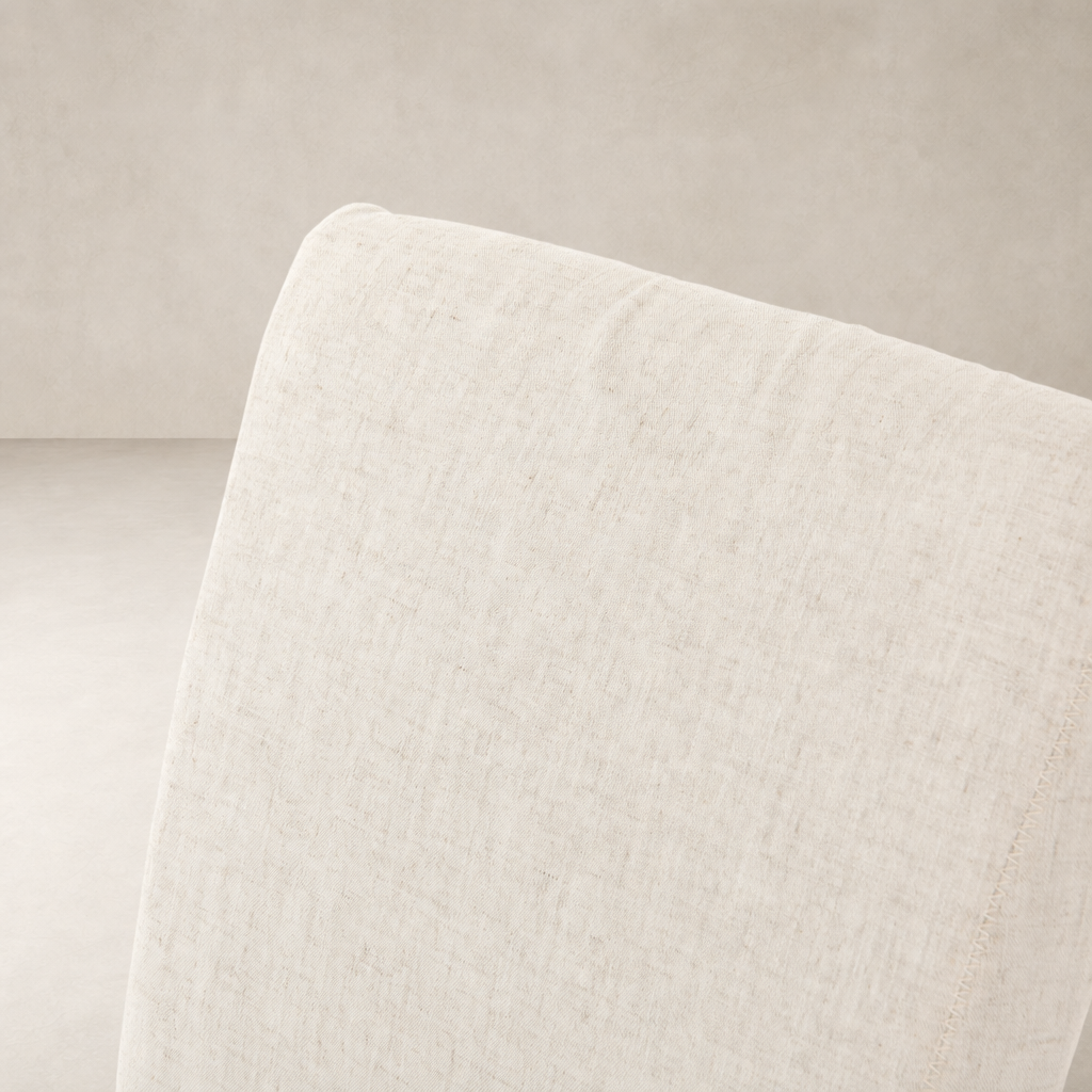 Sierra Slipcovered Dining Chair featuring light, textured fabric in neutral color close-up.