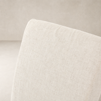 Sierra Slipcovered Dining Chair featuring light, textured fabric in neutral color close-up.
