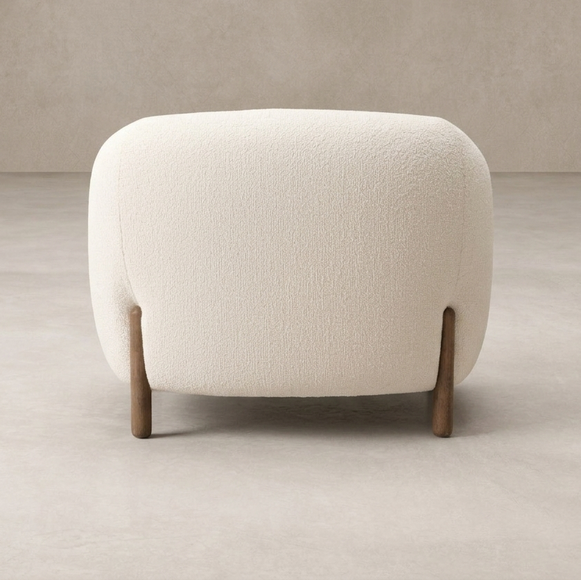 Back view of the Laurel Accent Chair featuring a textured cream upholstery and wooden legs.