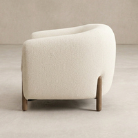 Side angle of the Laurel Accent Chair in soft beige upholstery with wooden legs.