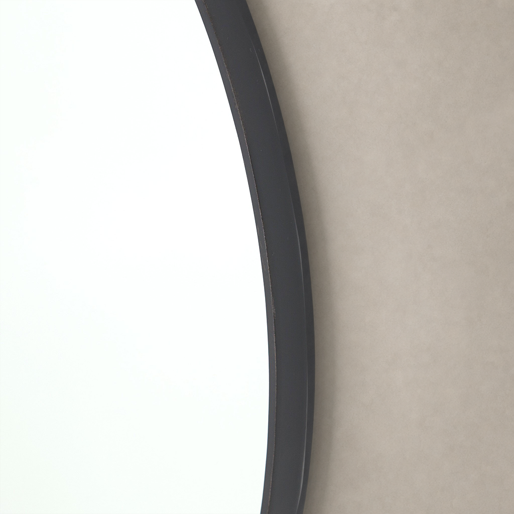 Curved, dark frame of the Vida Mirror against a soft, neutral background.