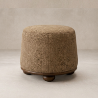 Close-up of the Bilbury Ottoman featuring a textured brown fabric and rounded wooden base.