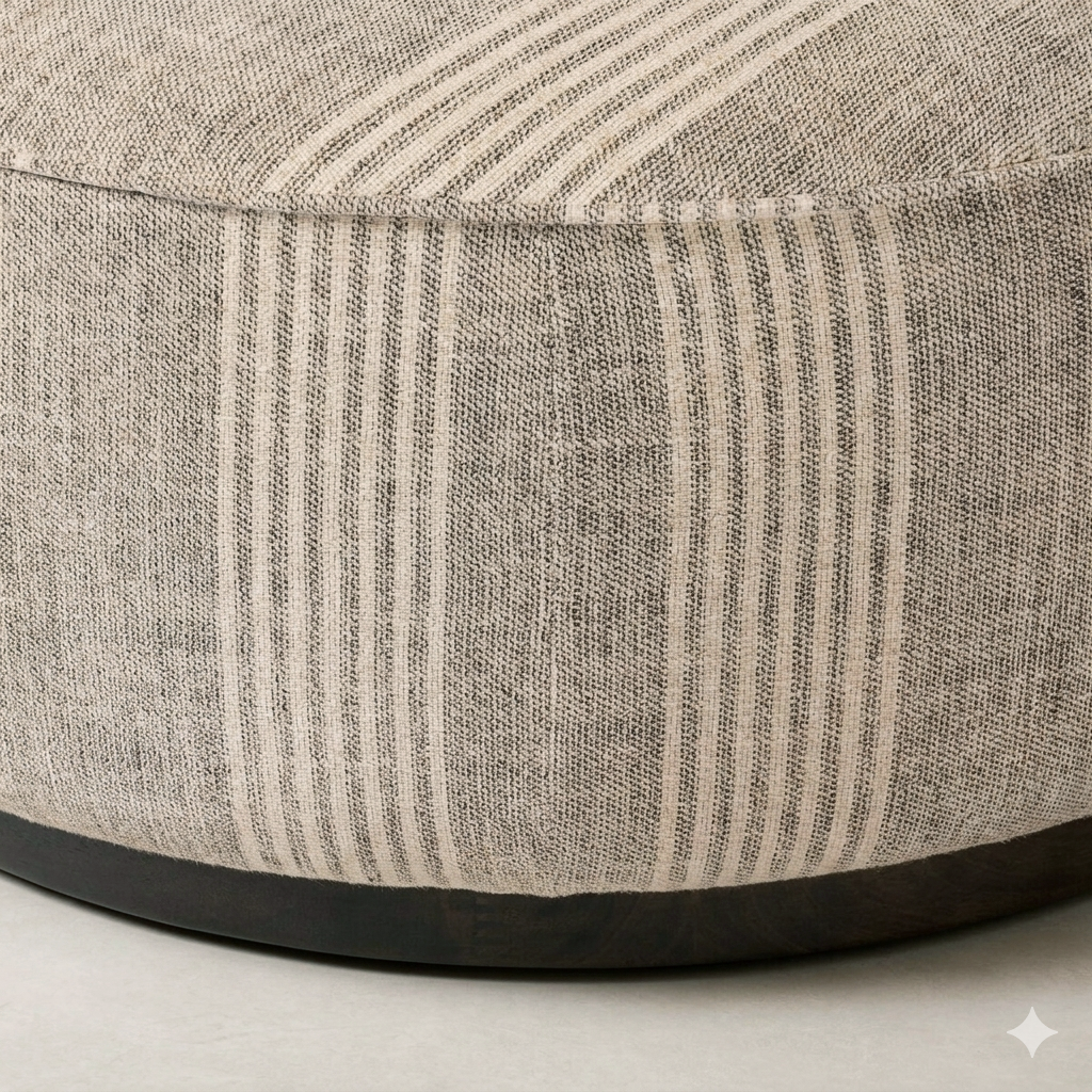 Detail of the Bilbury Large Round Ottoman showcasing its textured fabric and dark wood base.