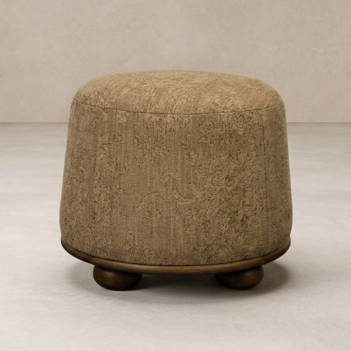 Close-up of the Bilbury Ottoman showcasing its textured fabric and rounded wooden base.