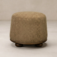 Close-up of the Bilbury Ottoman showcasing its textured fabric and rounded wooden base.